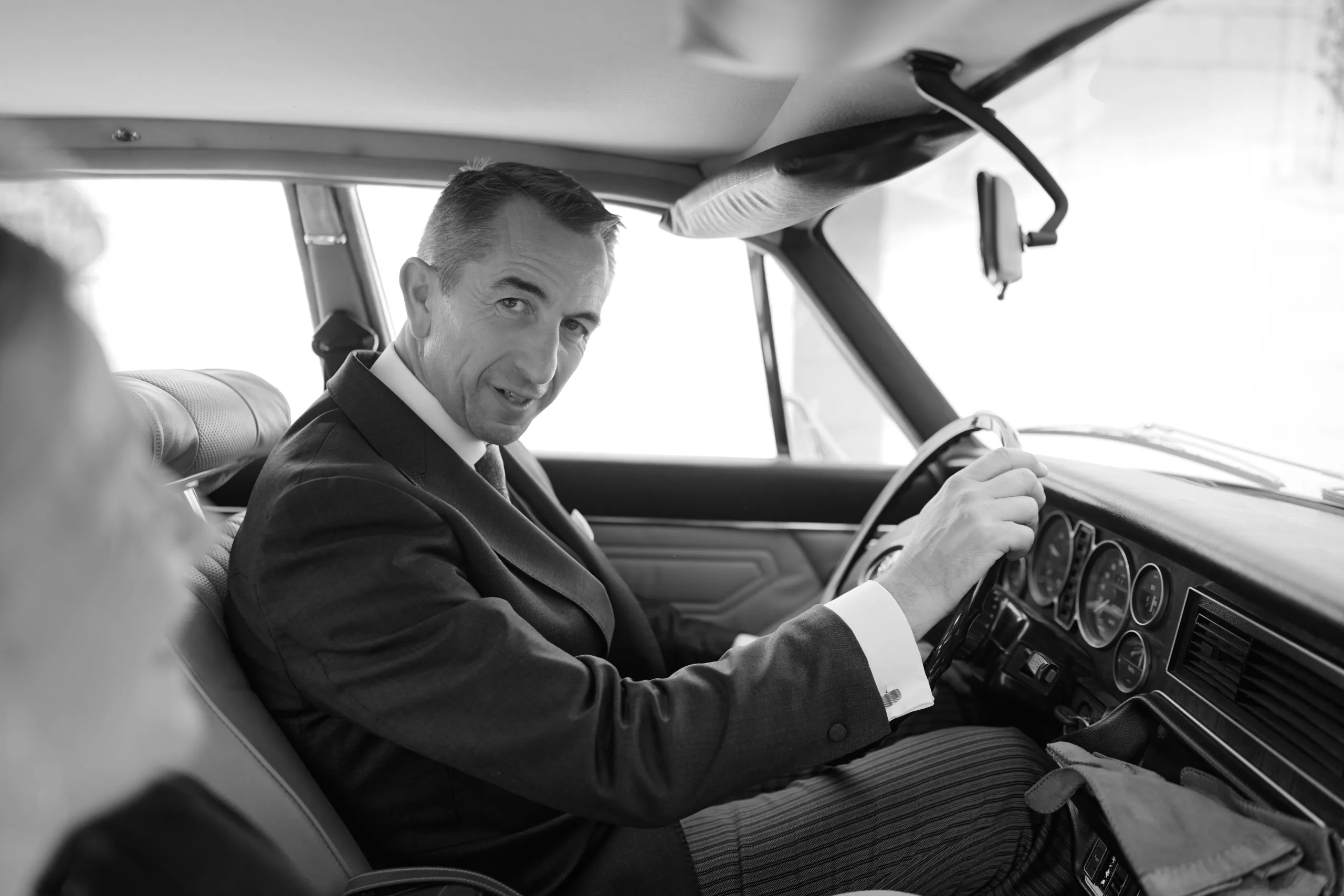 Un homme au volant d’une voiture, en noir et blanc