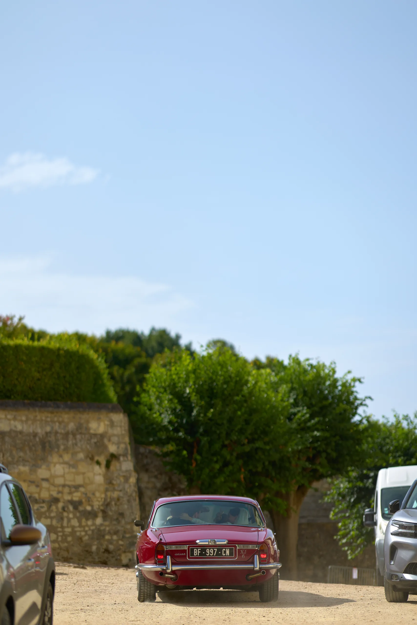 Une voiture rouge sur une place sous un ciel bleu