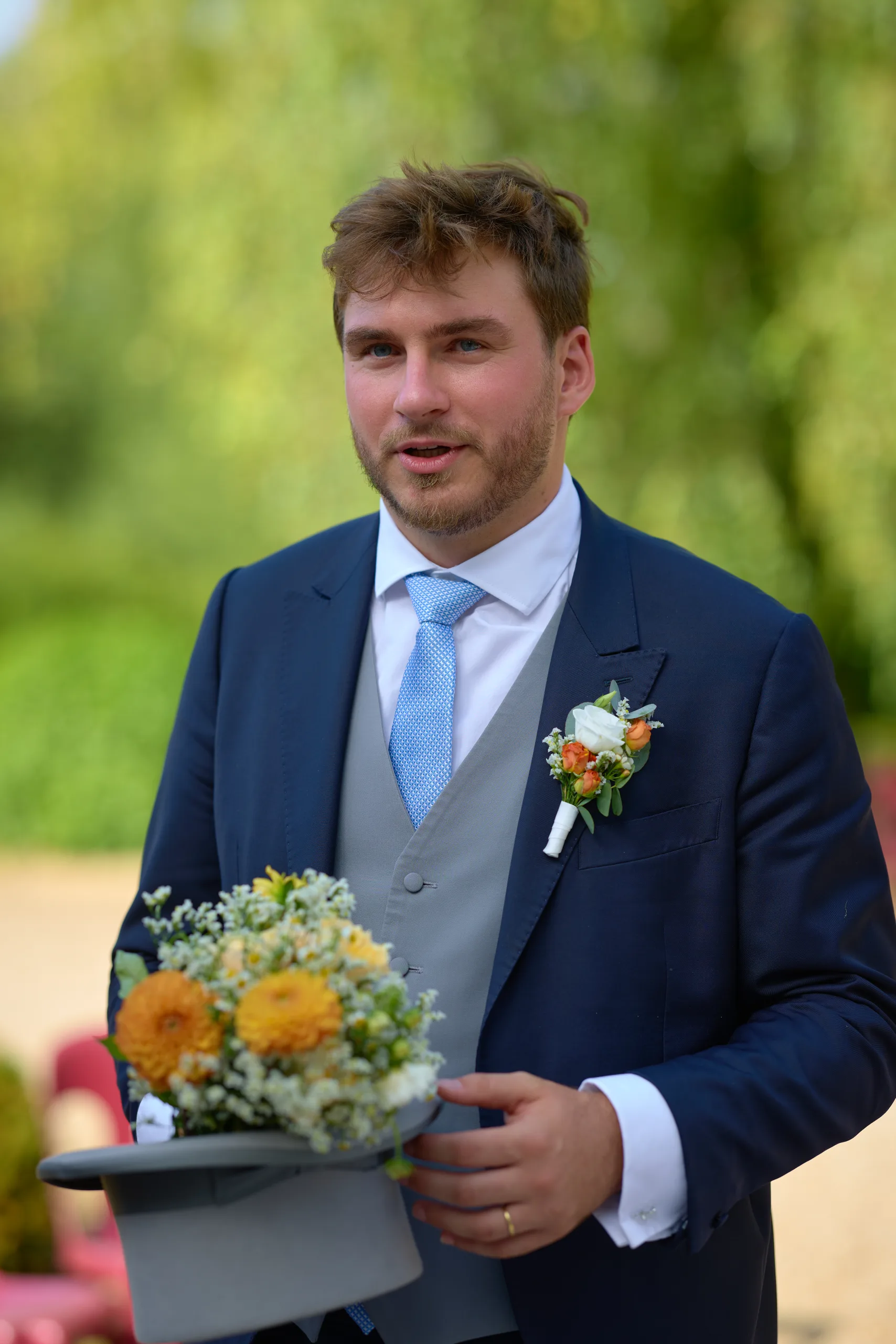 Le marié tient le bouquet de la mariée