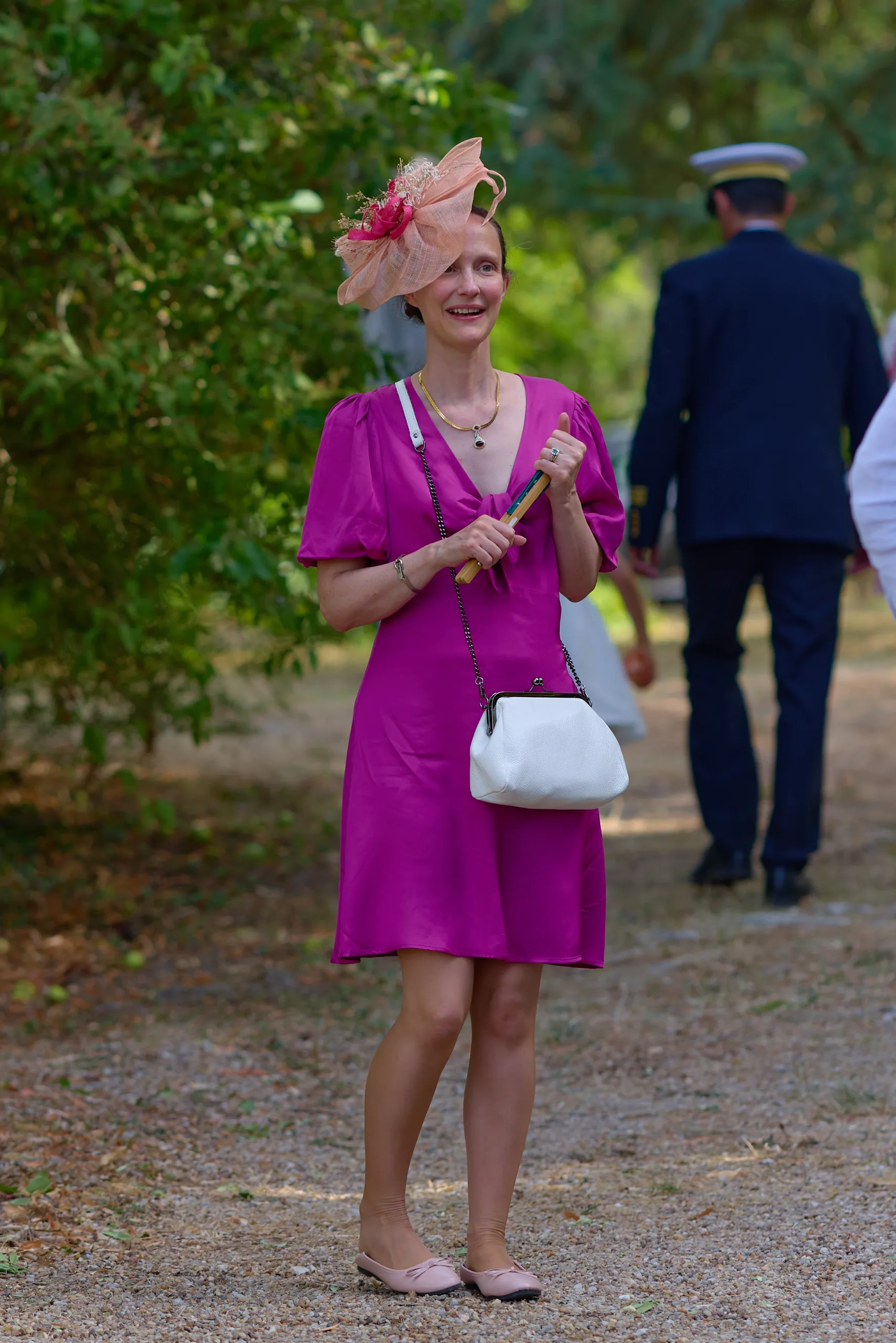Une invitée en robe rose dans un jardin