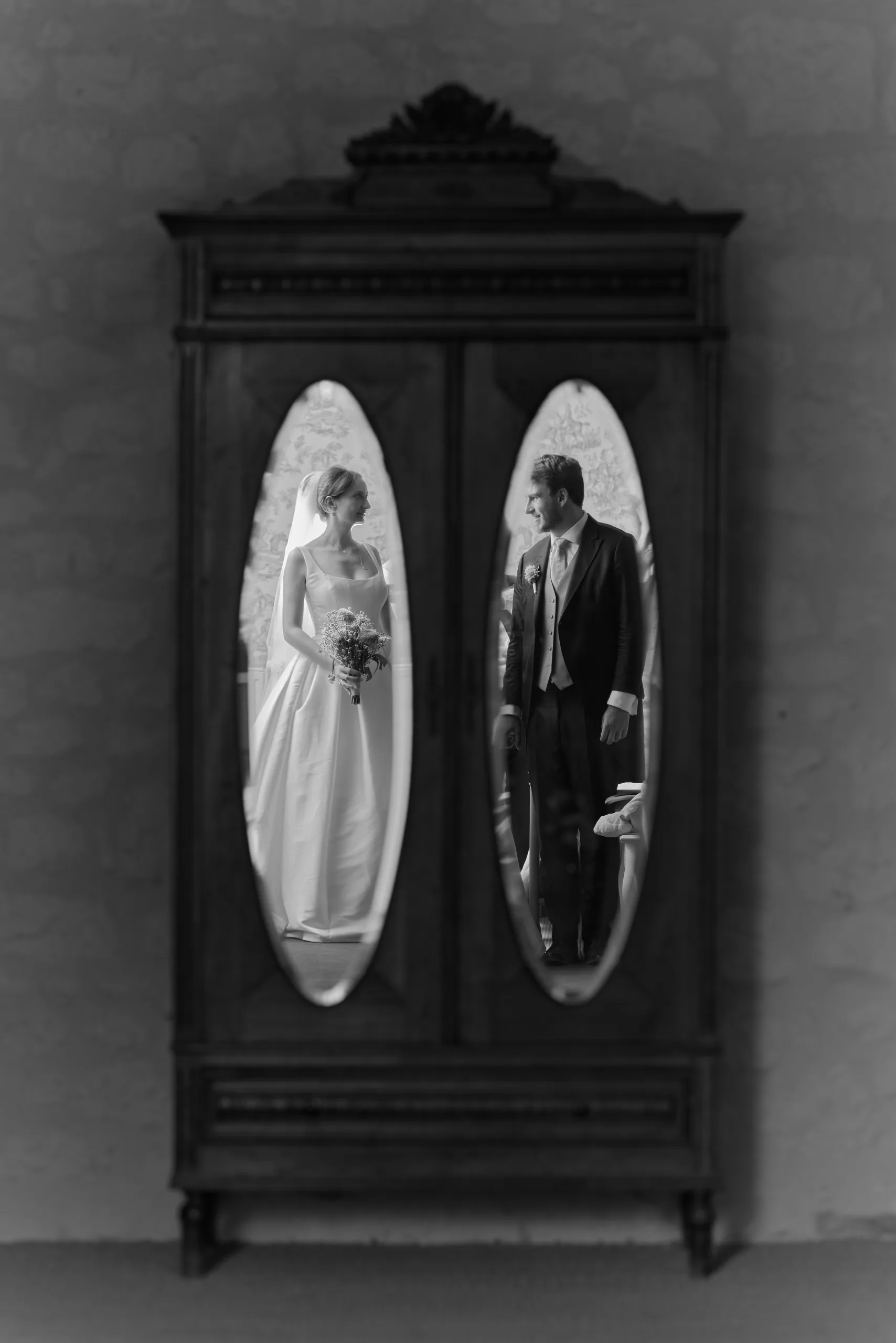 Les mariés reflétés dans les miroirs d’une armoire, en noir et blanc