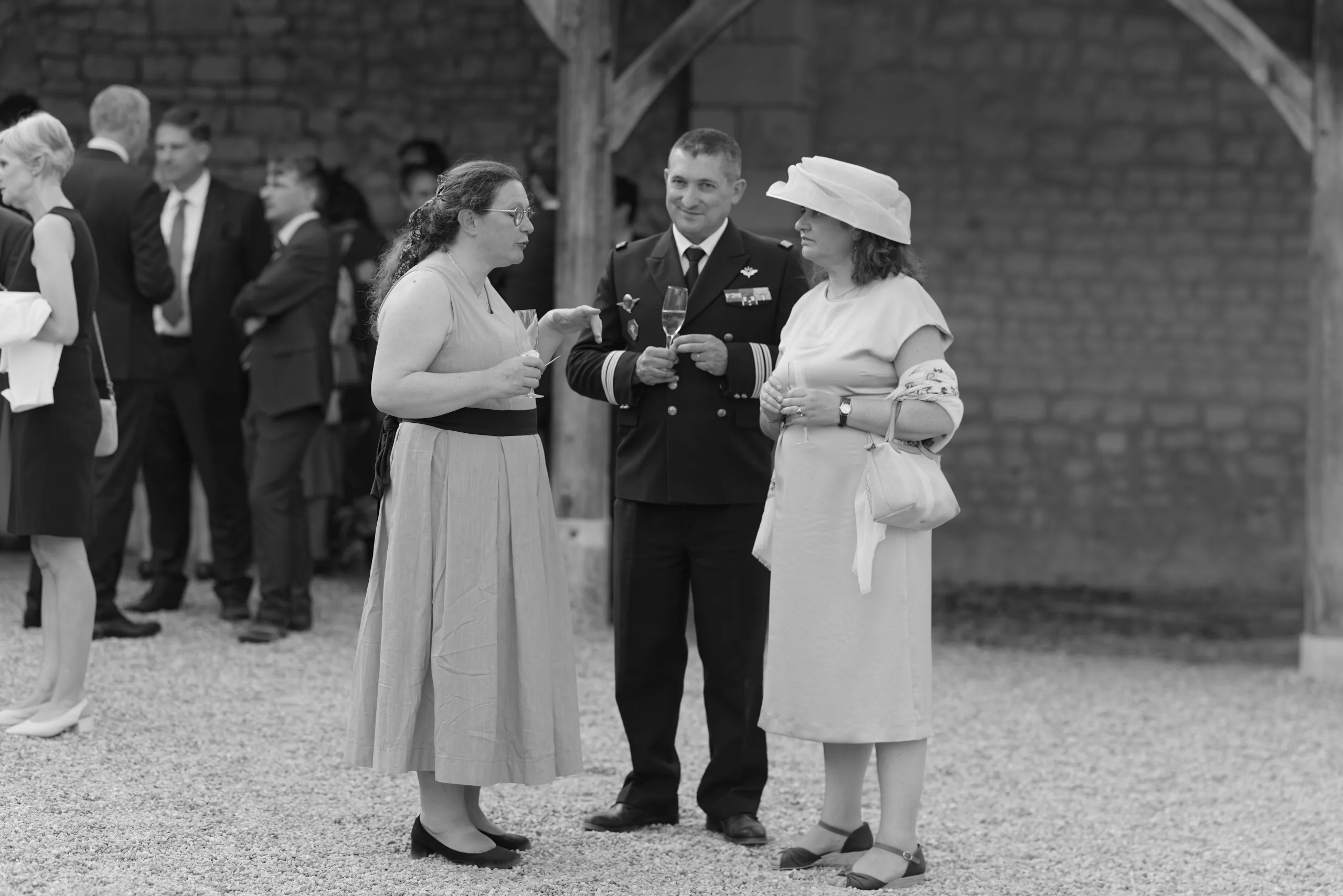 Des invités discutent pendant la réception, en noir et blanc