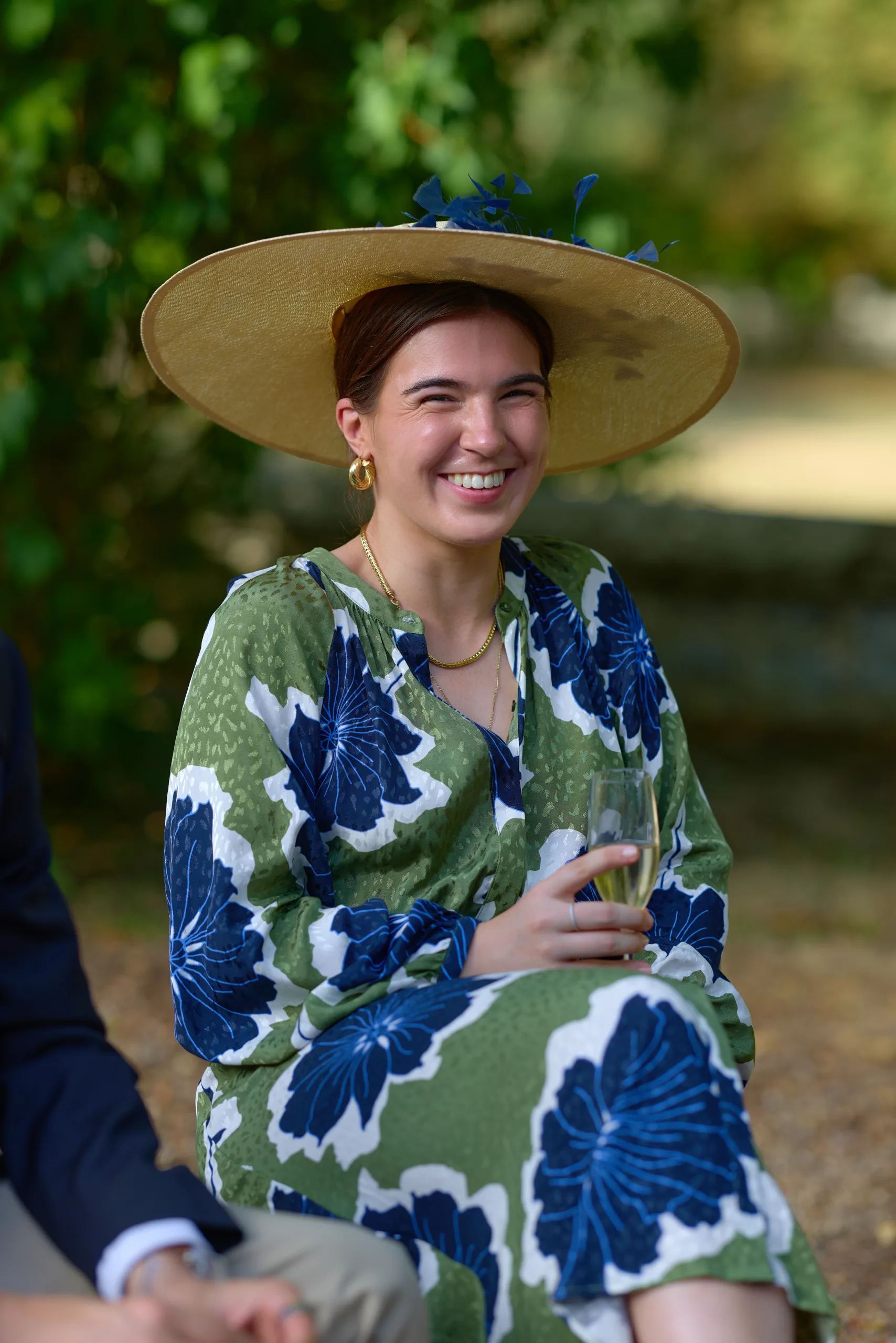 Une invitée en robe à motifs et chapeau de paille