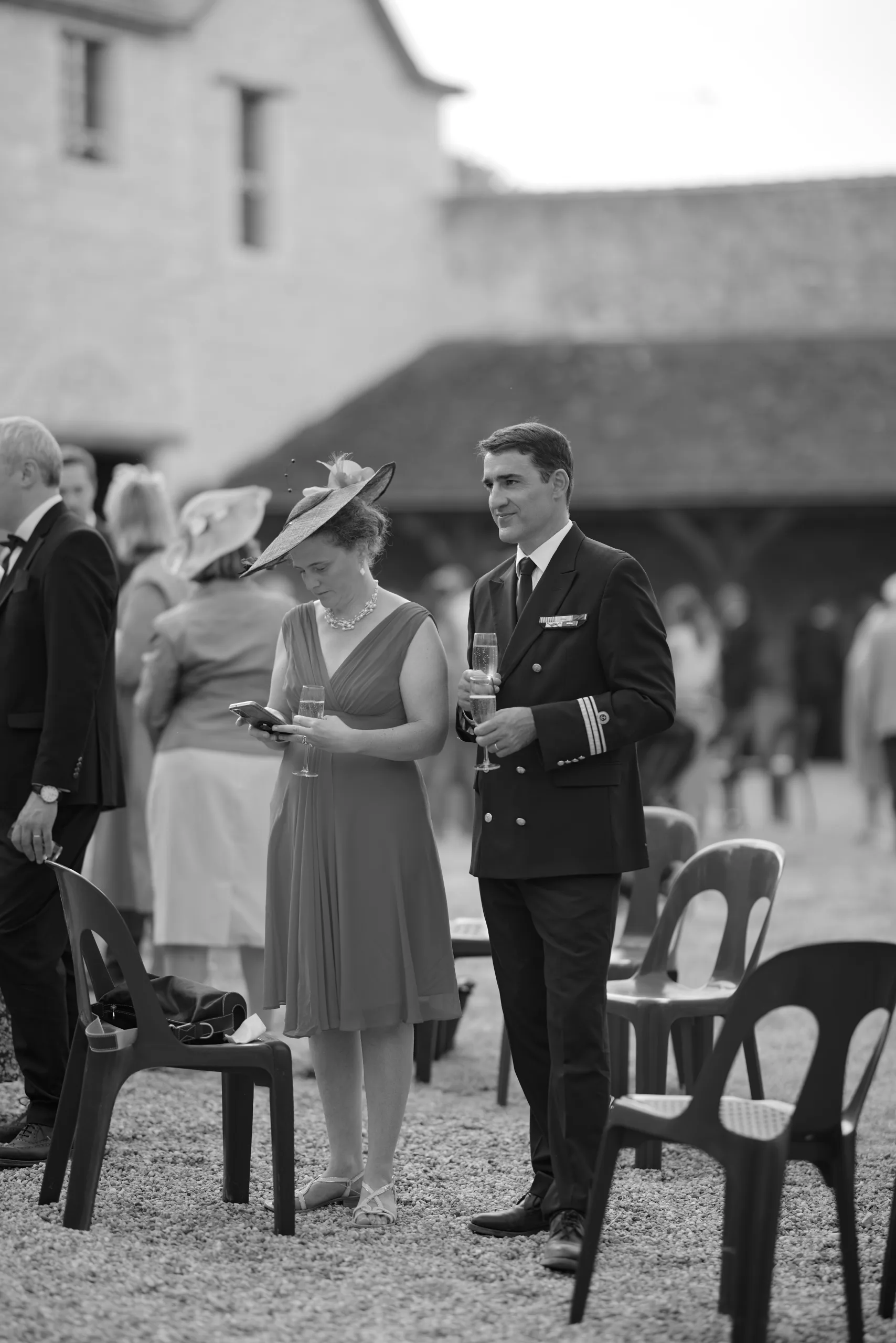 Des invités discutent dans le jardin, en noir et blanc