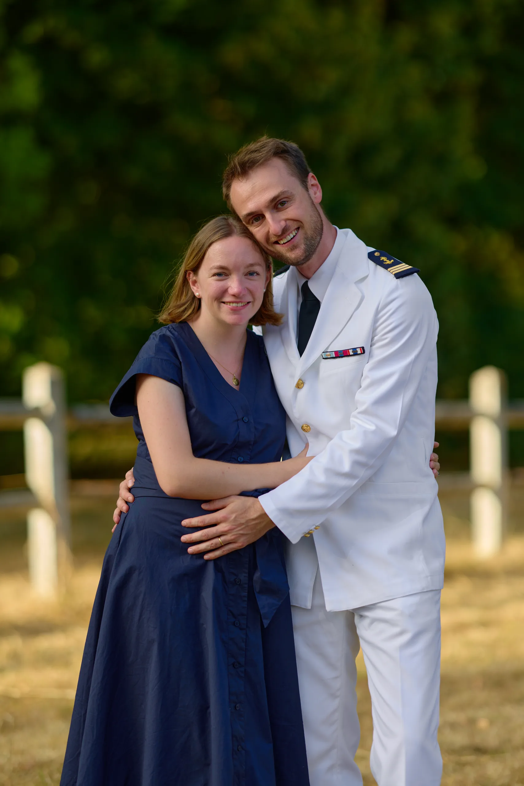 Un couple enlace le bébé qu’il porte dans le jardin