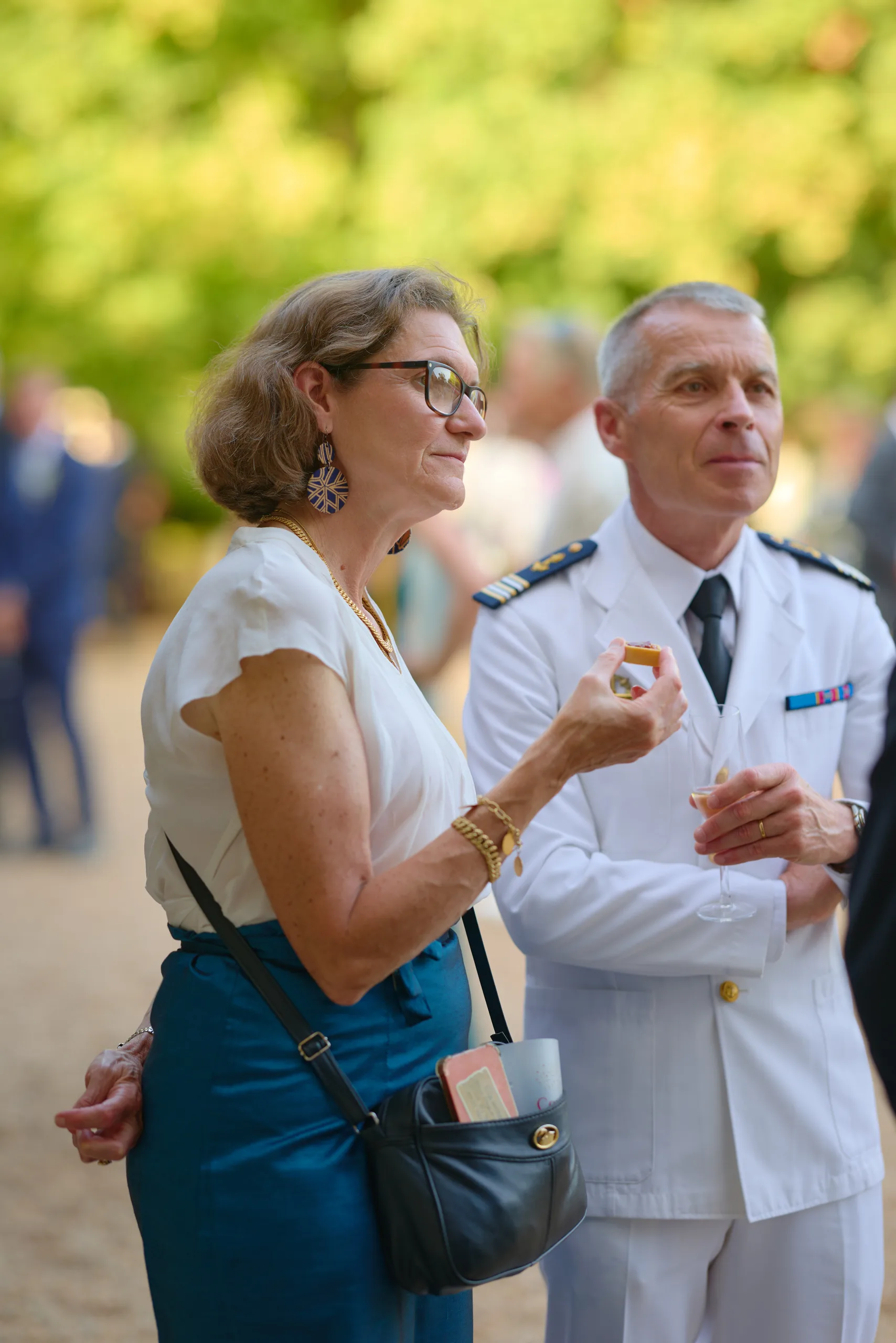 Une invitée discute avec un homme en uniforme blanc