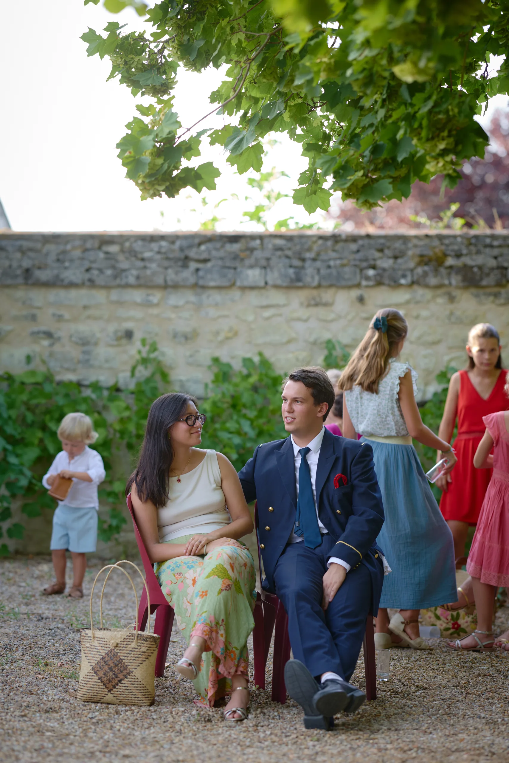 Un invité assis dans le jardin parmi les autres convives