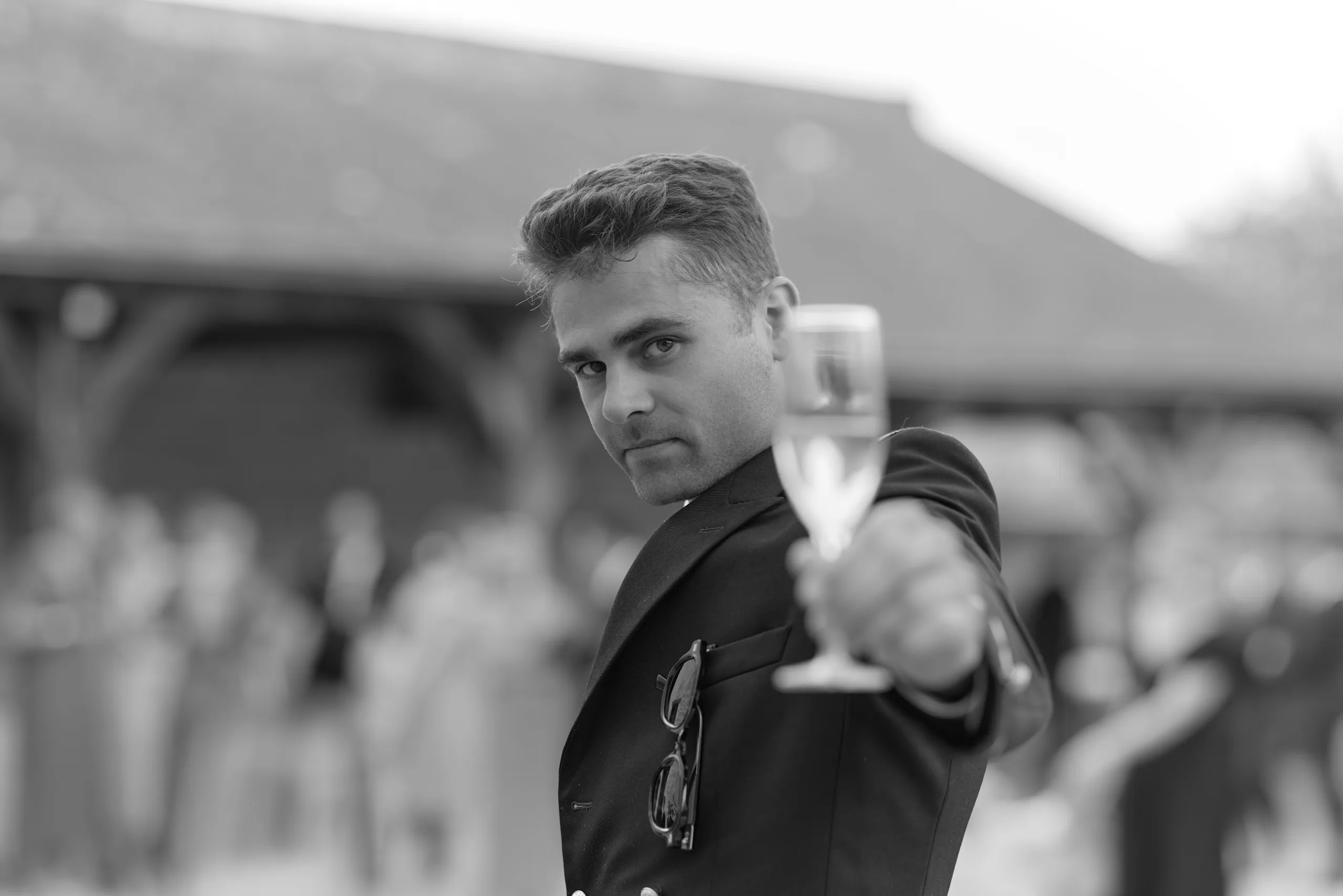Un invité tend la main vers l’objectif, en noir et blanc