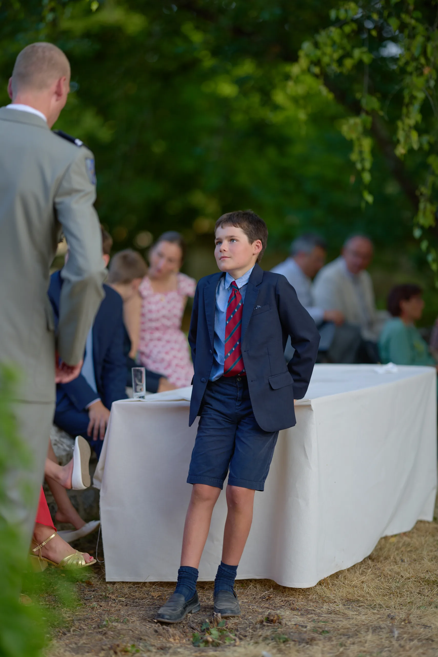 Un enfant en costume debout dans le jardin