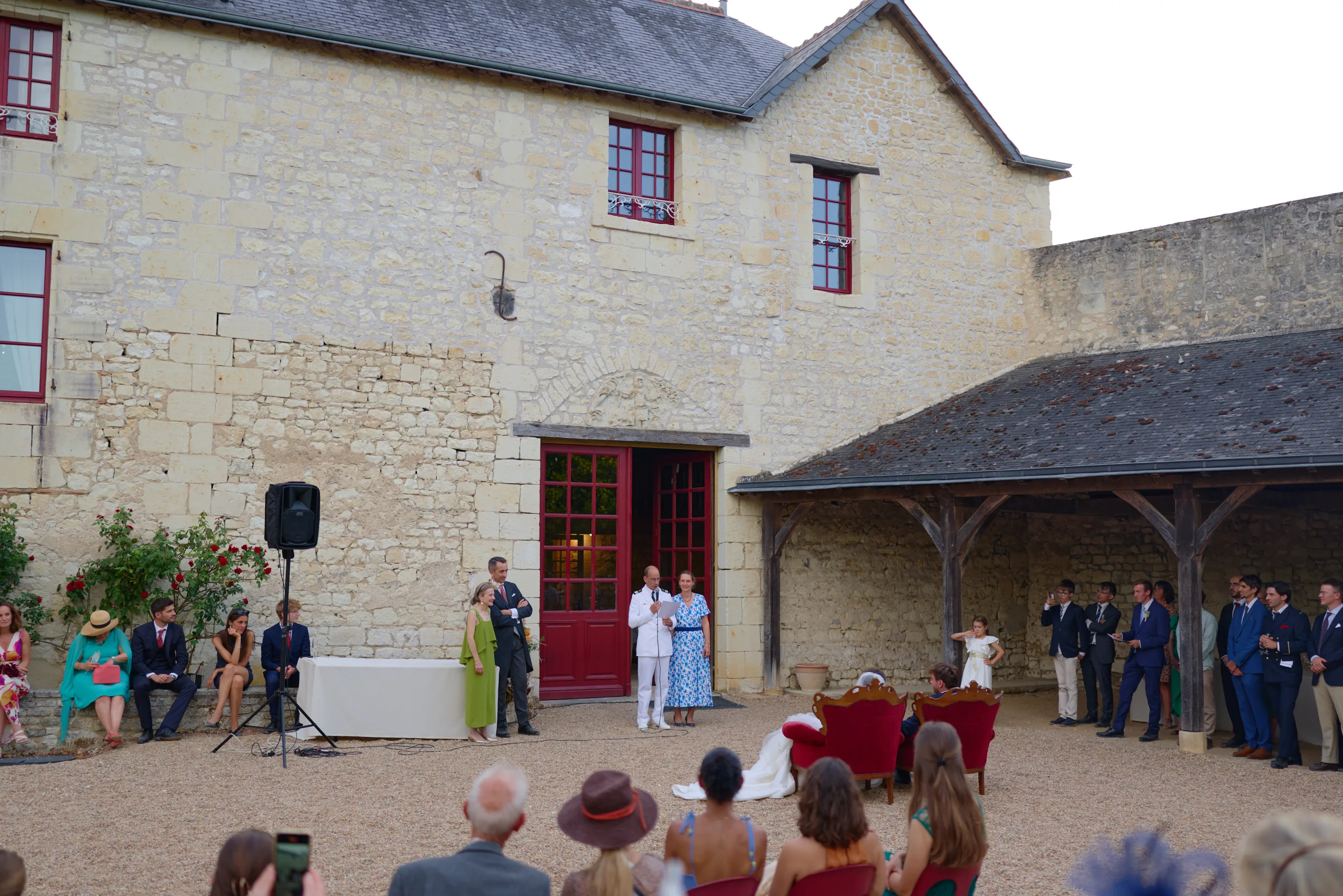 Les invités et les mariés réunis dans la cour du manoir