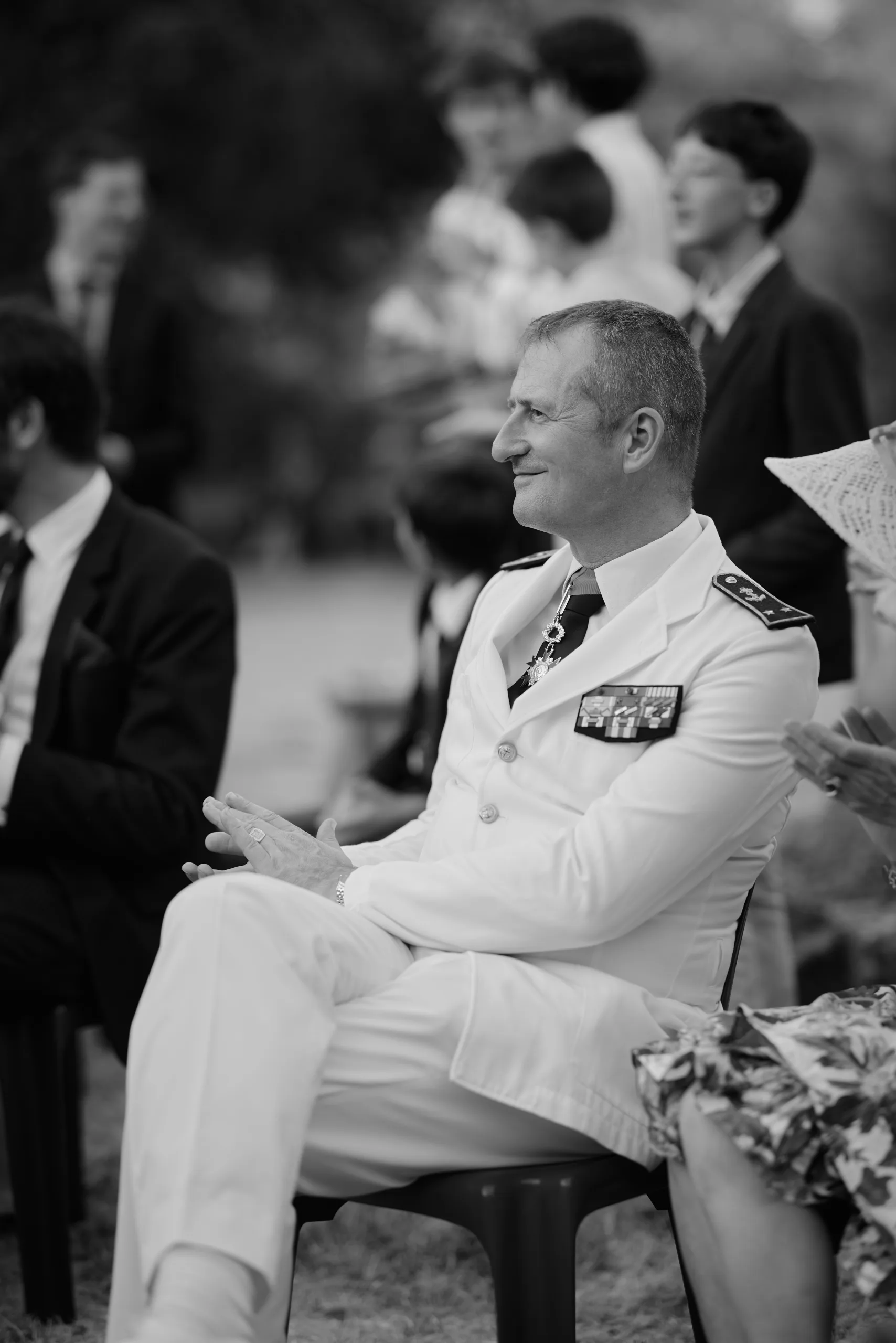 Un invité en uniforme blanc assis, en noir et blanc