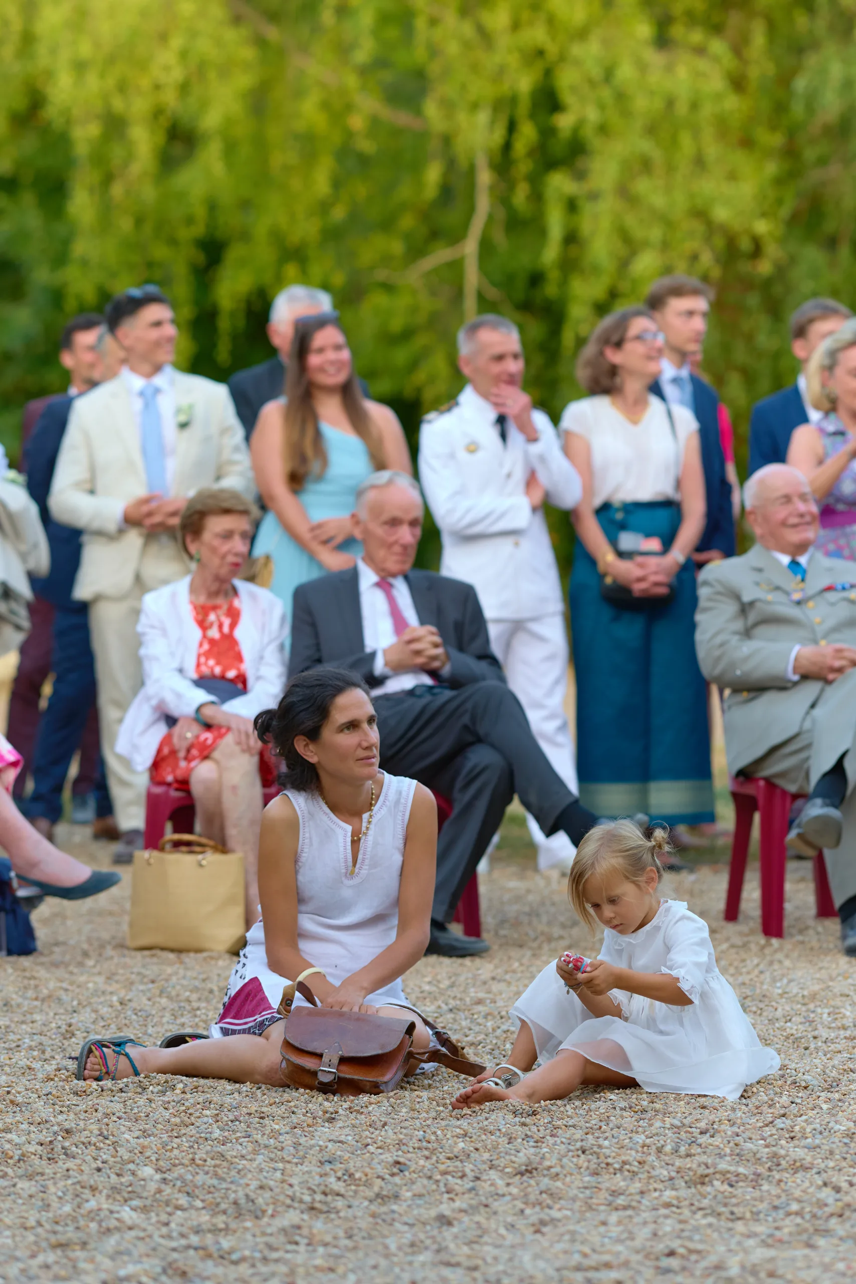 Les invités debout et des enfants assis dans la cour
