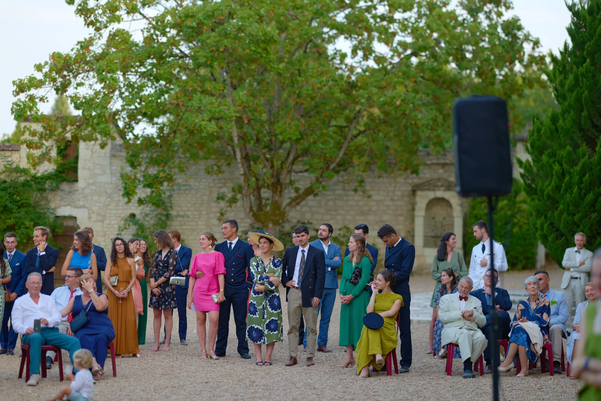 Les invités rassemblés près d’une enceinte dans la cour