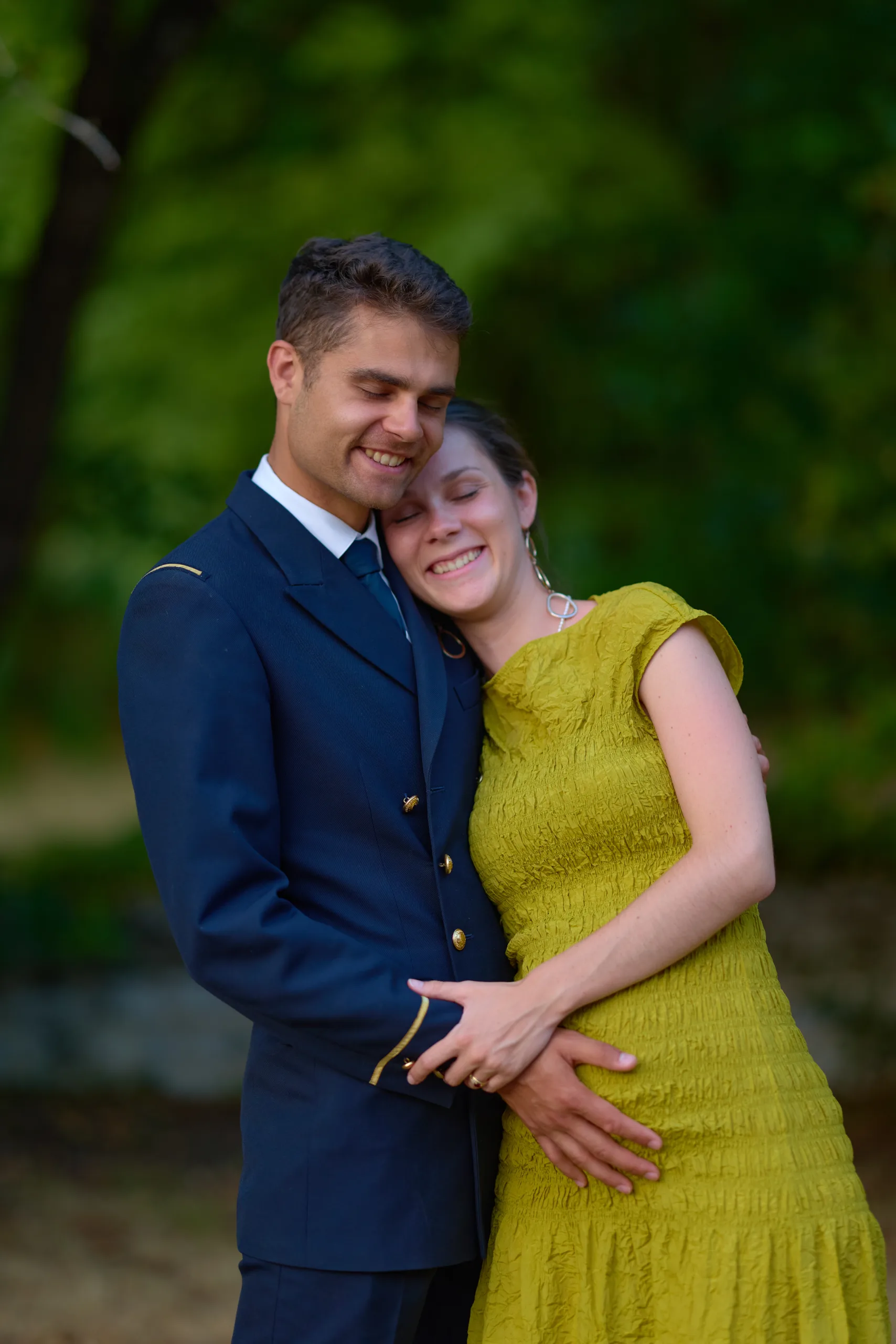 Un couple pose enlacé dans le jardin