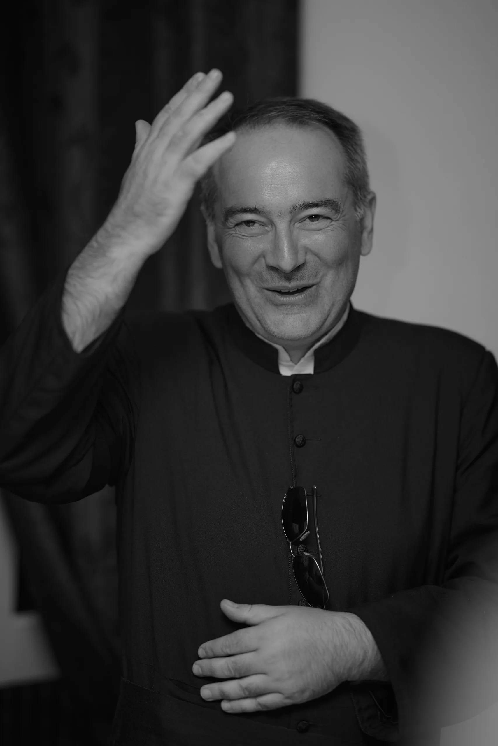 Un invité en habit religieux sourit, en noir et blanc