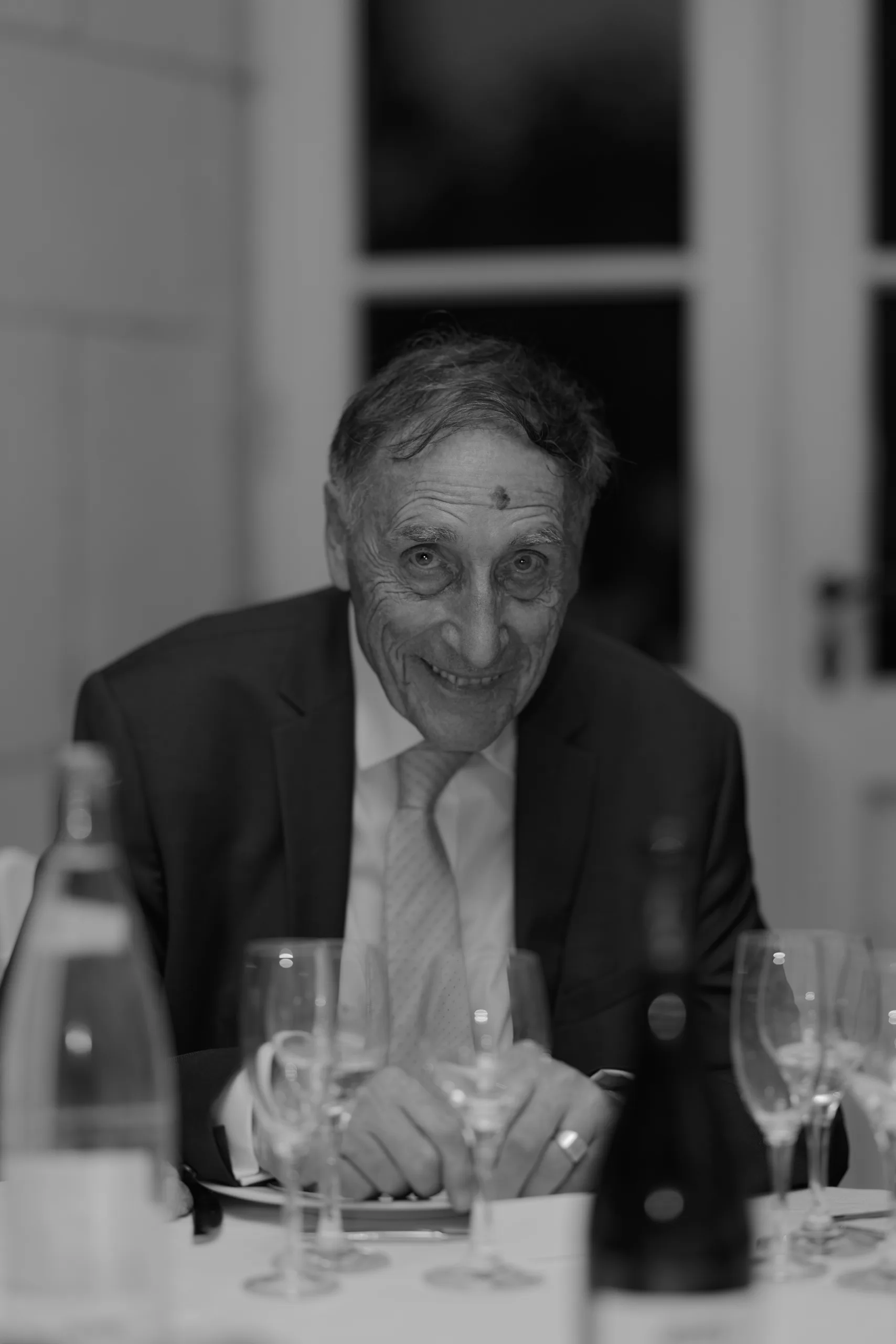 Un invité sourit à table, en noir et blanc