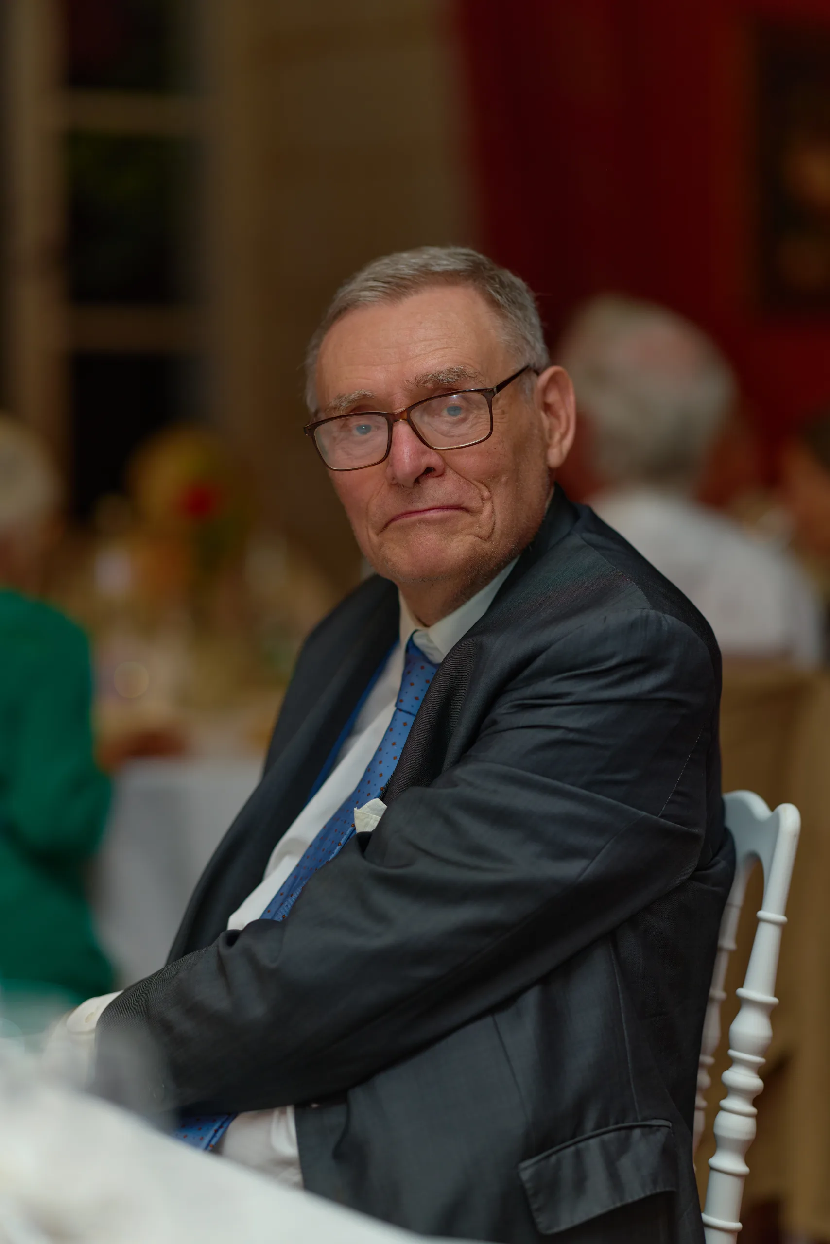 Un invité portant des lunettes, assis pendant le repas