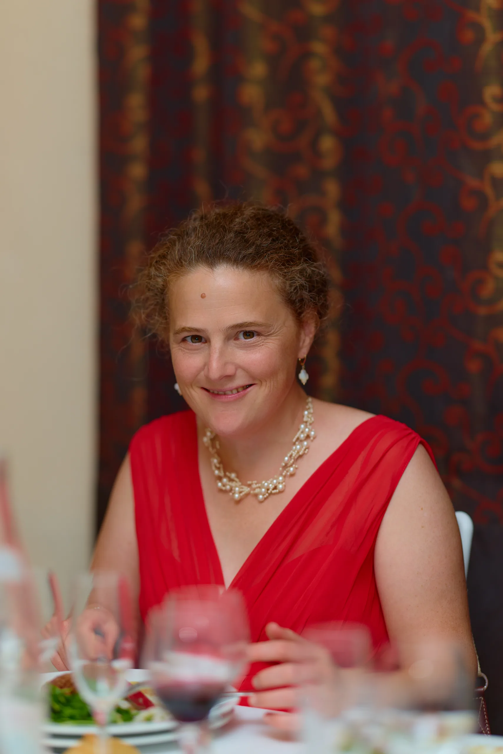 Une invitée en rouge sourit à table