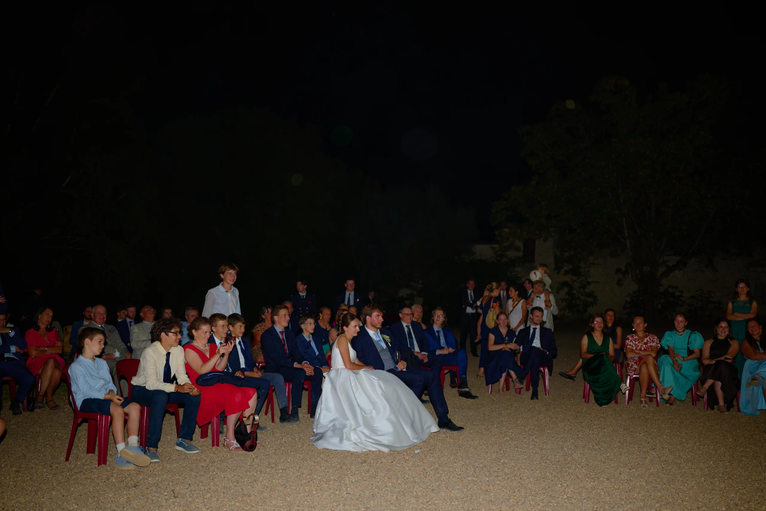 Les mariés et leurs invités dans la cour pendant la soirée