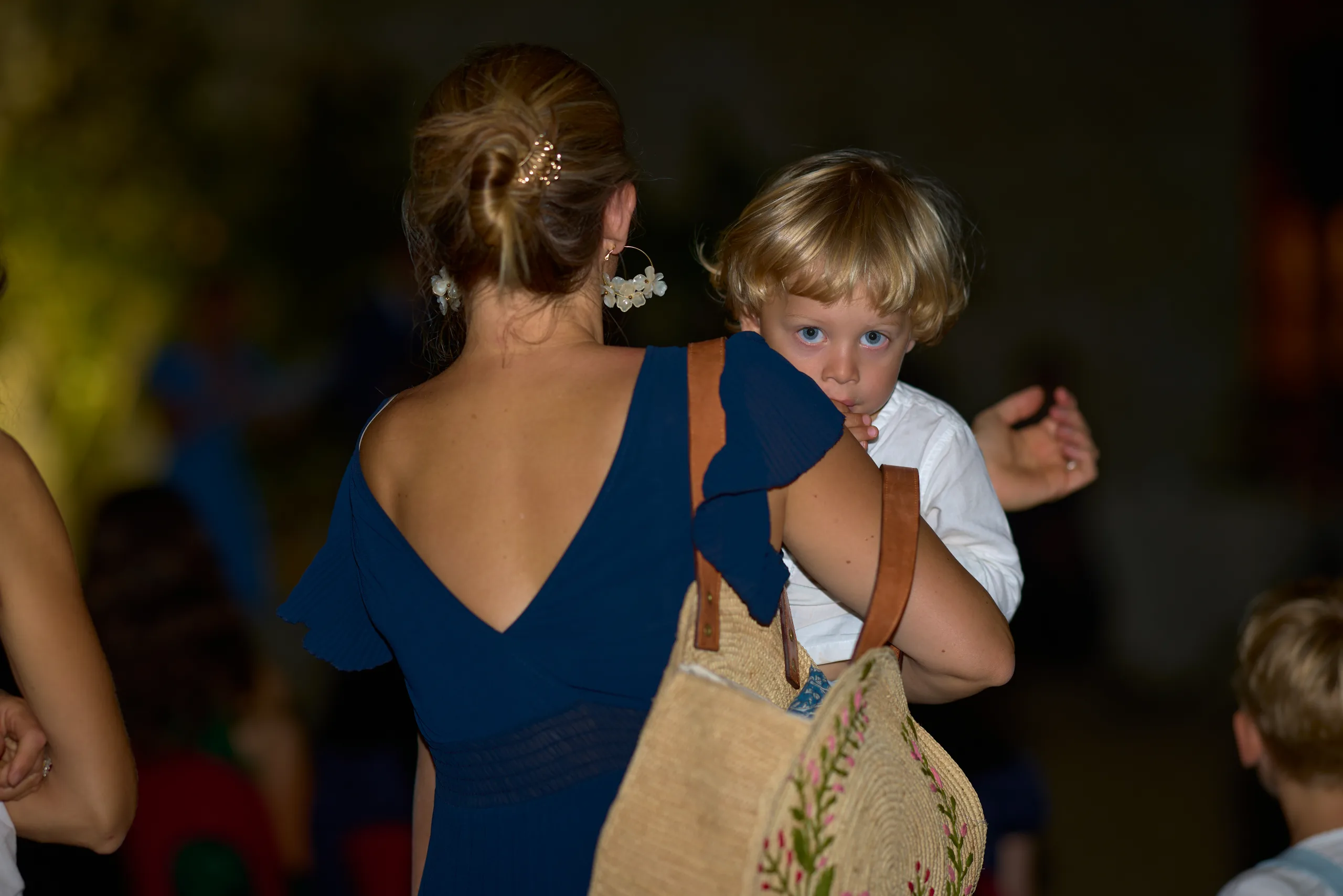 Une femme porte un enfant pendant la soirée