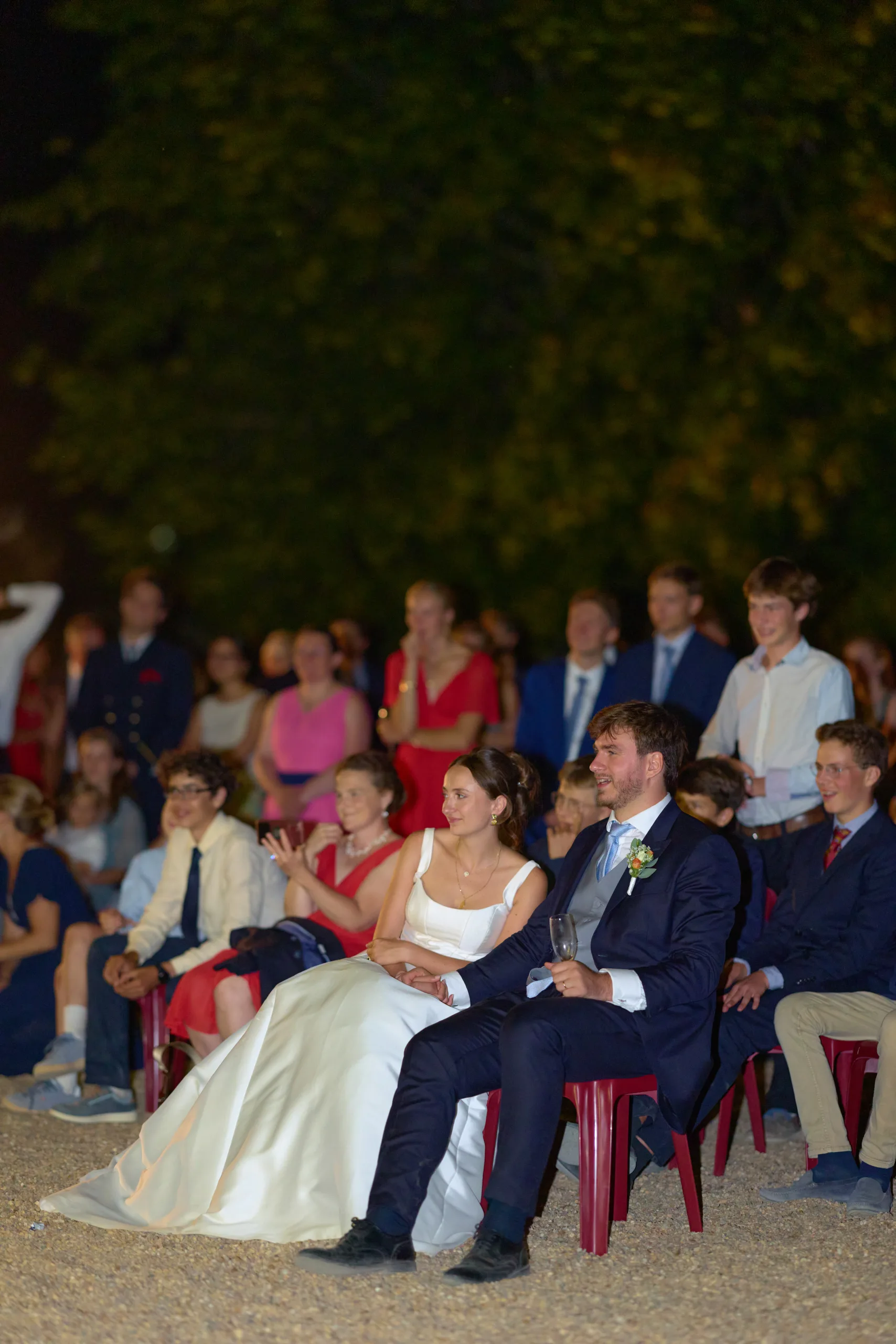Les mariés assis parmi leurs invités pendant la soirée