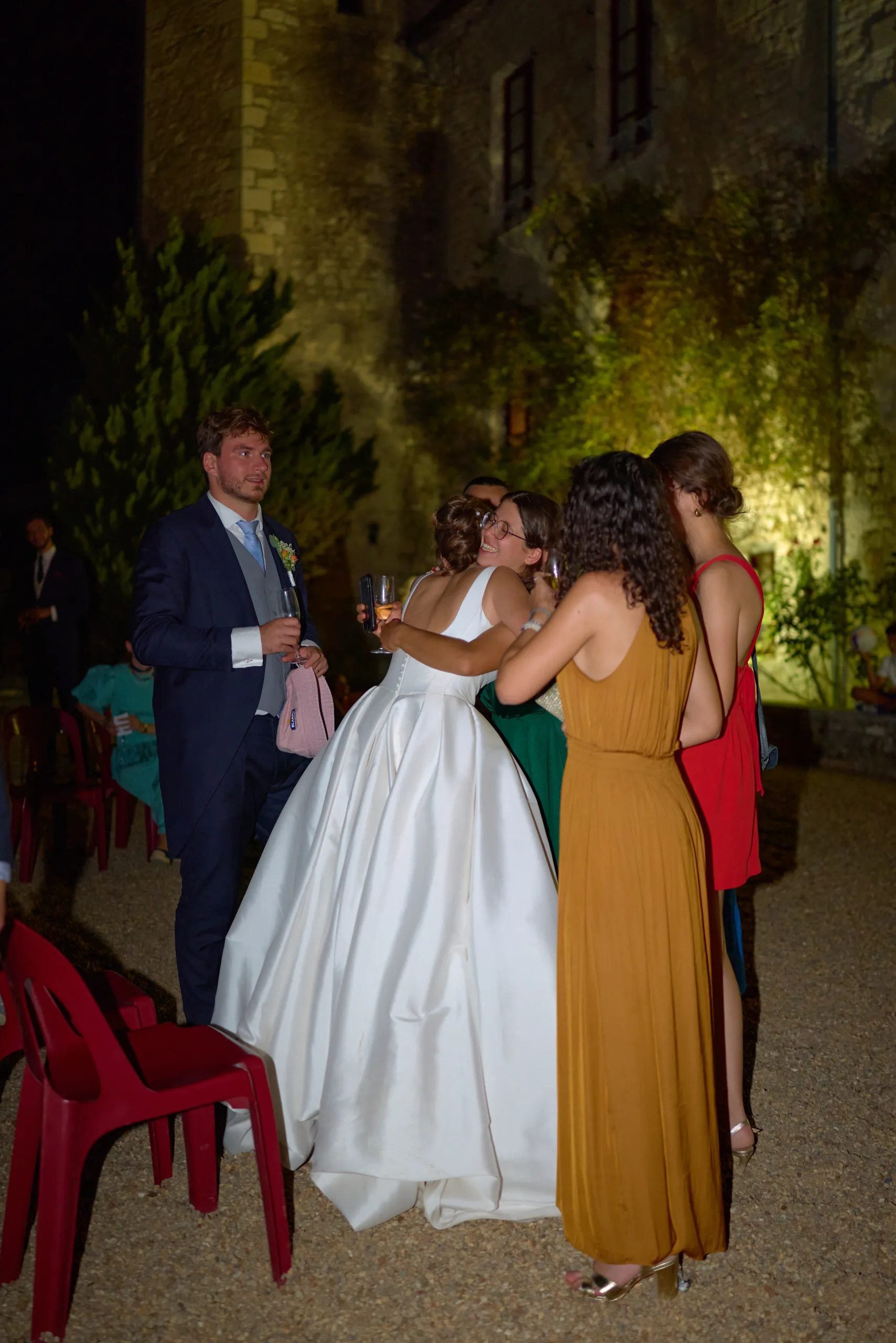 Les mariés et une invitée dans la cour pendant la soirée
