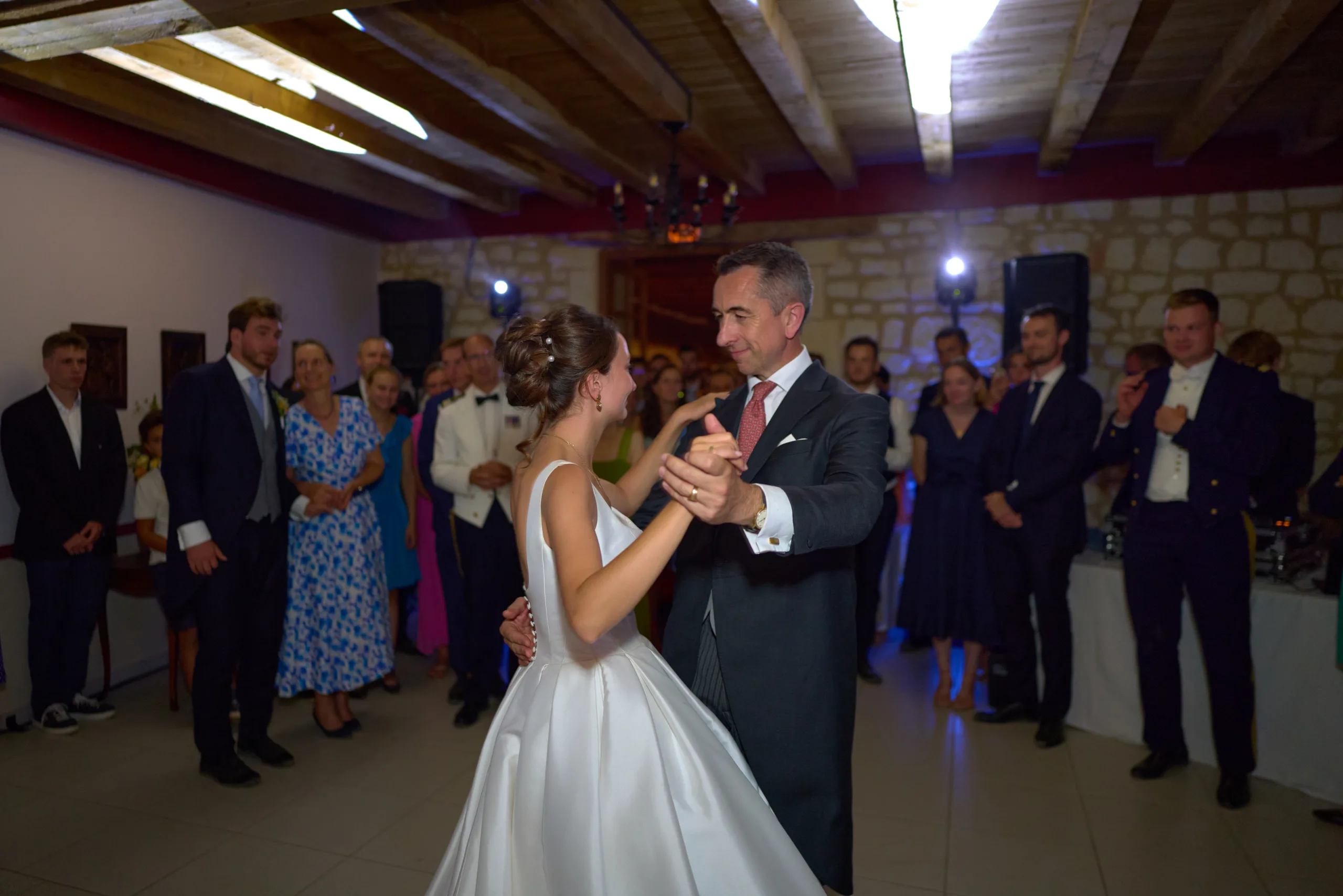 La mariée et un invité dansent devant les convives