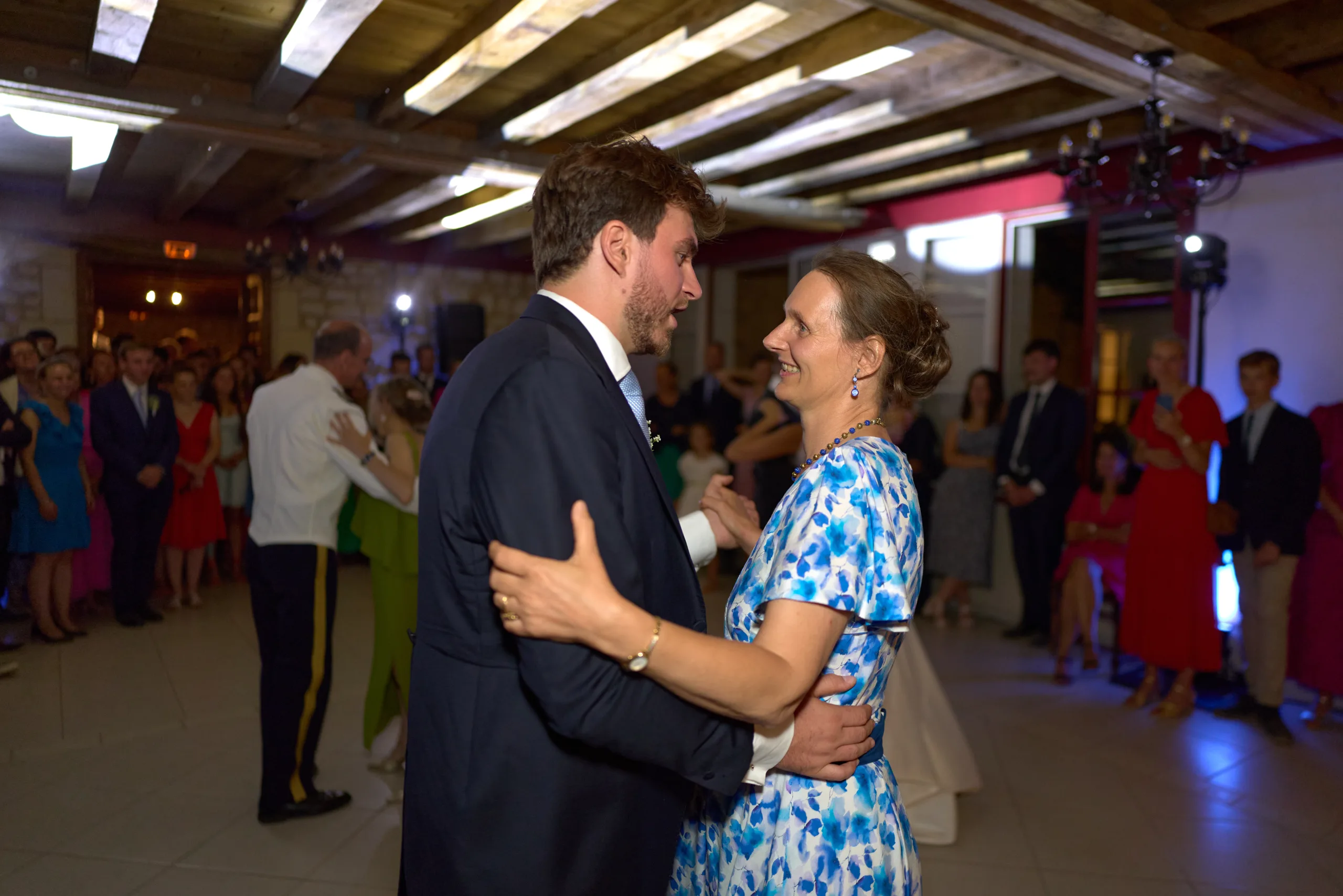 Le marié danse avec une invitée devant les autres convives