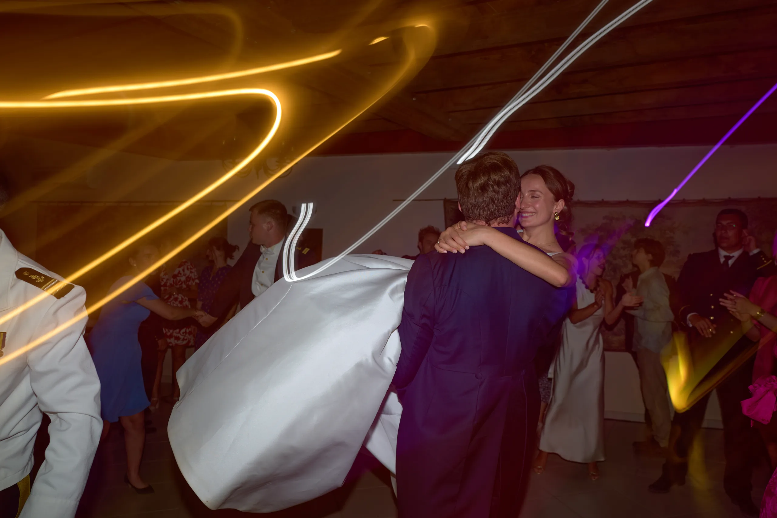 Un couple dansant sous les traces de lumière de la soirée